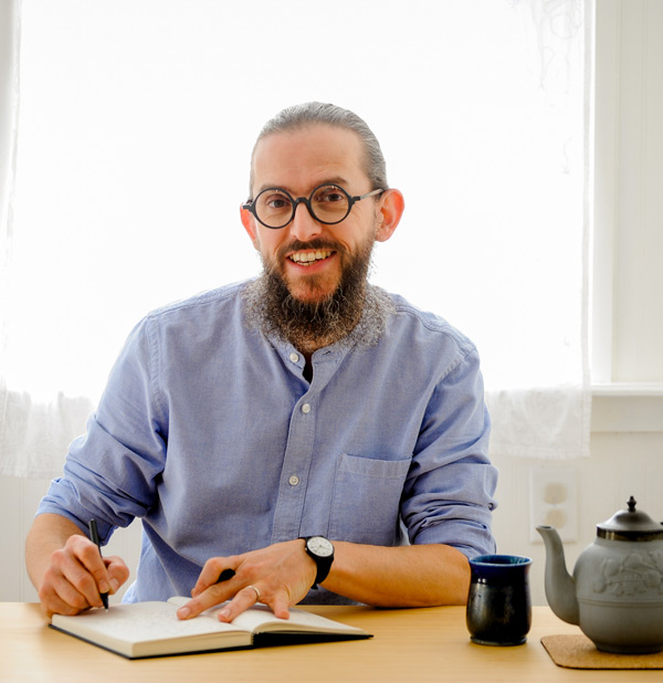 ThomasD-105-cropped-content-fill Thomas Deneuville sitting at his desk writing in his journal with a cup of tea. Thomas Deneuville is a creativity coach and mindfulness meditation teacher.