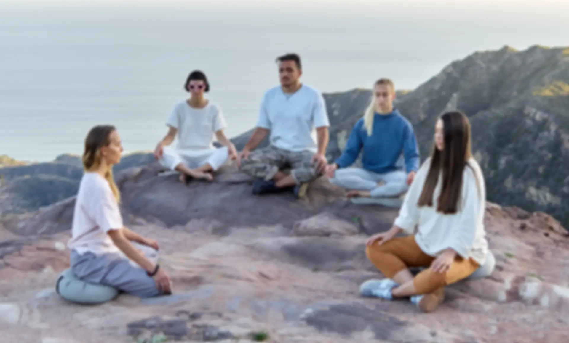 A group of five people meditating on the top of a mountain, what a mindful community for creatives could look like